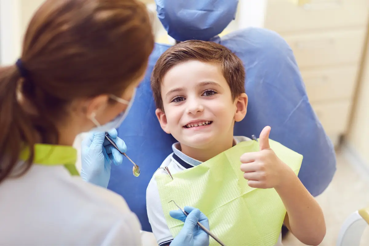 Niño sonriente durante una consulta dental adaptada