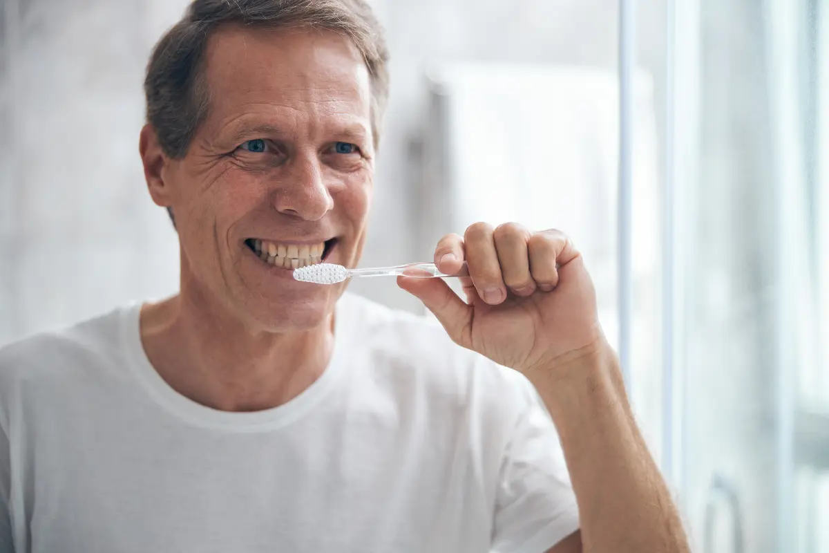 Adulto mayor realizando el cepillado dental diario
