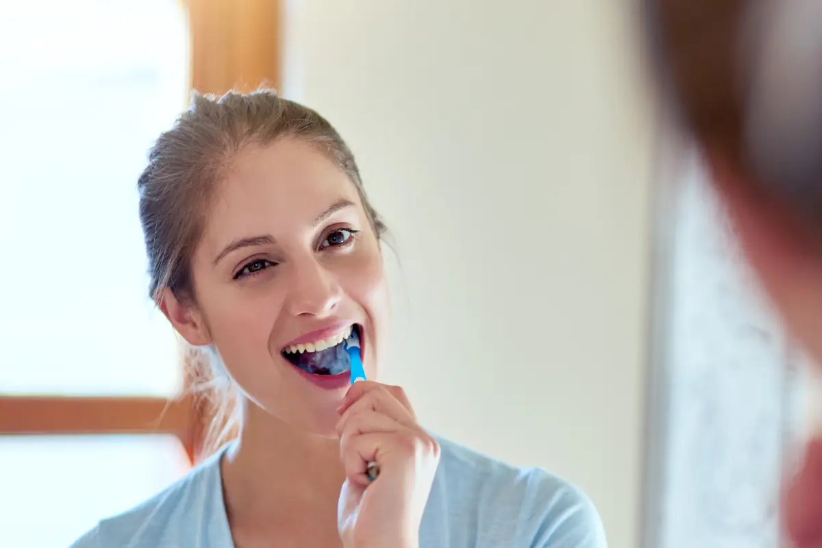 Niña cepillándose los dientes para cuidar su boca